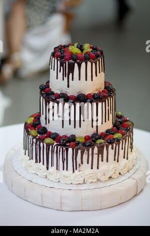 Three-tiered cake with berries Stock Photo