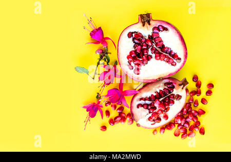 Pomegranate fruit with flowers, flat lay view. Stock Photo