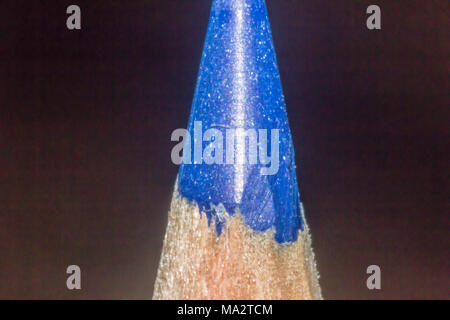 Macro photo with a flash blue pencil on a dark background. Mechanical sharpening.A good image for the site about art,education,decoration, drawing. Stock Photo