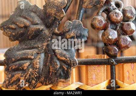 Old strong wooden planks with obsolete steel grape ornate, close-up background Stock Photo
