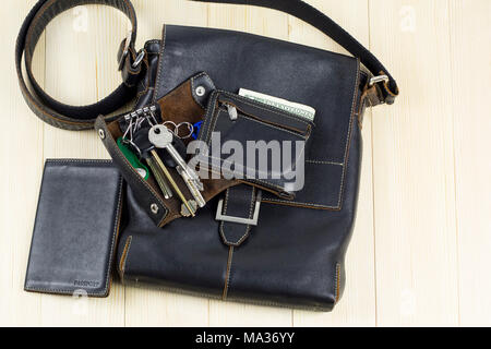 A set of men's leather accessories, a bag, a passport cover, a wallet, a handbag, a keychain case on a light background Stock Photo