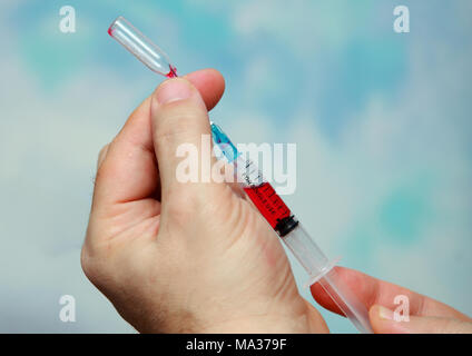 Close-up of the hand of a person typing in a syringe medicine Stock Photo