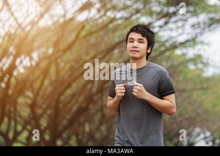 young fitness man running in the park Stock Photo