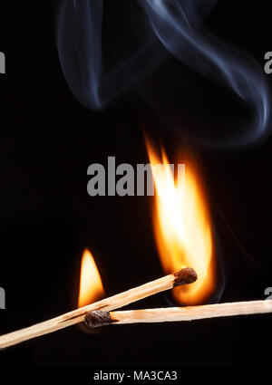 two burning match with the flame isolated on black background Stock Photo