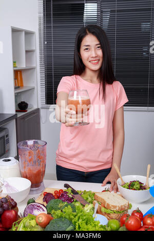 young woman with smoothies in glass at kitchen room Stock Photo