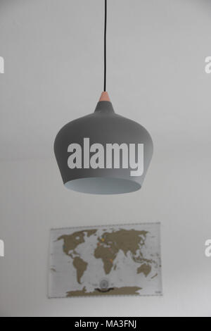 Pendant light in grey with a map of the world in the background Stock Photo