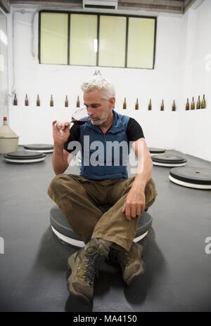 Winegrower Frank Cornelissen sitting in his amphora cellar in Passopisciaro, Sicily, Italy Stock Photo