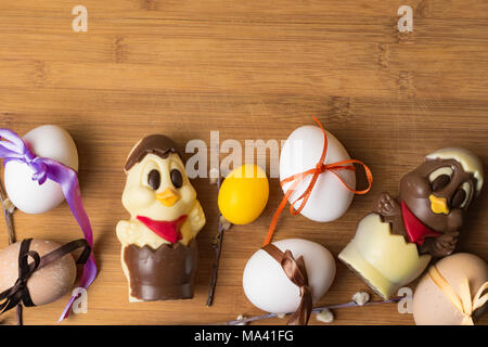 easter eggs with color ribbon and chocolate cute chicken on the orange background, april holiday Stock Photo