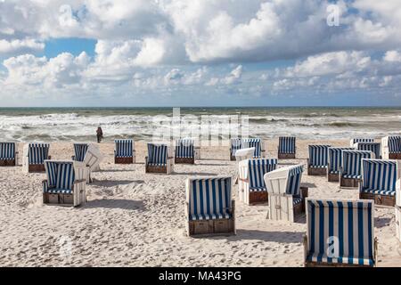 A beach with roofed wicker beach chairs on the island of Sylt, Germany Stock Photo