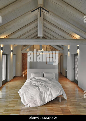 modern bedroom in the attic room with wooden ceiling and wooden floor Stock Photo