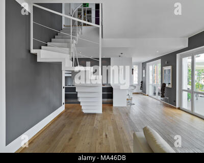 interiors shots of a modern apartment in the foreground the iron staircase on the background the kitchen while floor is made of wood