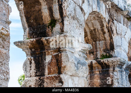 Ancient rows of arc columns in Pula CoWooden door in ancient medieval fortress wallliseum monument Stock Photo