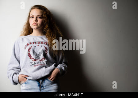 A moody attrractive young 13 thirteen year old teenage adolescent girl , UK Stock Photo