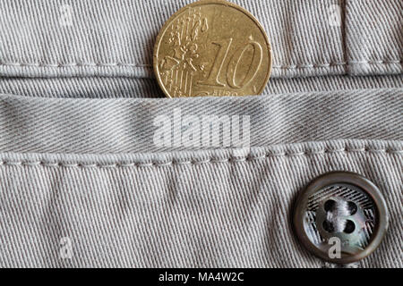 Euro coin with a denomination of 10 euro cents in the pocket of white denim jeans with button Stock Photo