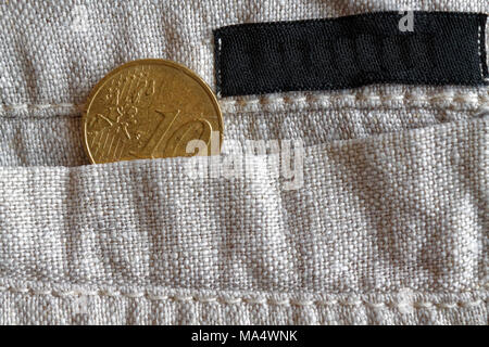 Euro coin with a denomination of 10 euro cents in the pocket of linen pants with black stripe Stock Photo
