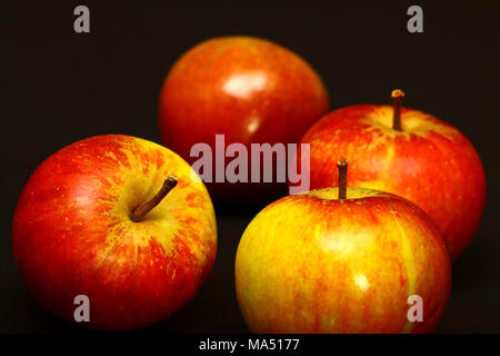 Four red ripe apples isolated on a black background Stock Photo