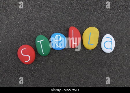 Stella, feminine given name with multicolored stones over black volcanic sand Stock Photo