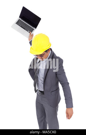 very angry engineer is throwing away his laptop isolated on a white background Stock Photo