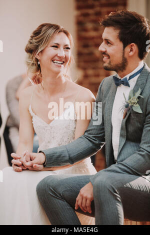 Bridal couple, sitting, holding hands, smiling, Stock Photo