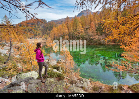 A tourist staring at the small lake near Crampiolo known as Witches Lake, Alpe Veglia and Alpe Devero Natural Park, Baceno, Verbano Cusio Ossola province, Piedmont, Italy Stock Photo