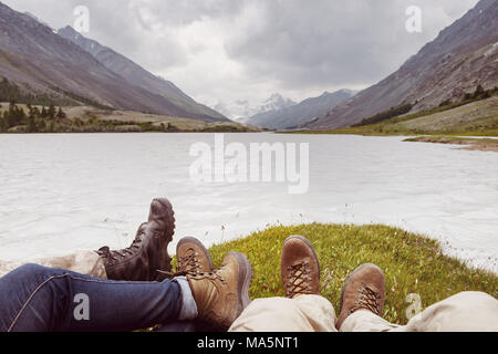 Tourirm adventures concept with closeup photo of legs against mountains lake Stock Photo