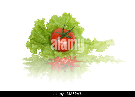 Fresh tomato lying on green lettuce leaf. Isolated on white with clipping path Stock Photo