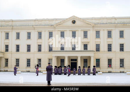 Irish guards from the Queens Guard regiments preparing for the Changing of the Guard ceremony with an inspection in the snow at Wellington Barracks Stock Photo