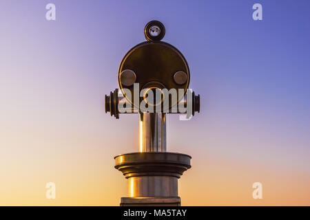 Close-up on binoculars with a beautiful evening sky with copy space. Stock Photo