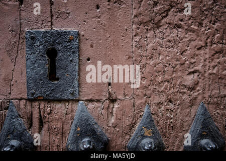 Rusty keyhole in old wooden door with steel nails, selective focus, copy space Stock Photo