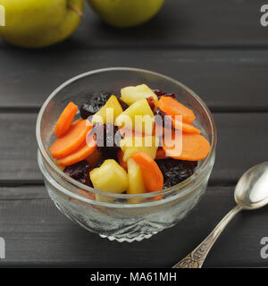 Tzimmes or tsimmes in a vintage glass bowl on the dark wooden table. A traditional Ashkenazi Jewish sweet stew made of carrot, apples, honey and dried Stock Photo