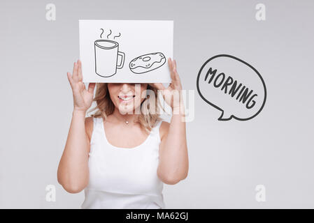 Optimistic woman smiling and starting her morning with tasty coffee Stock Photo