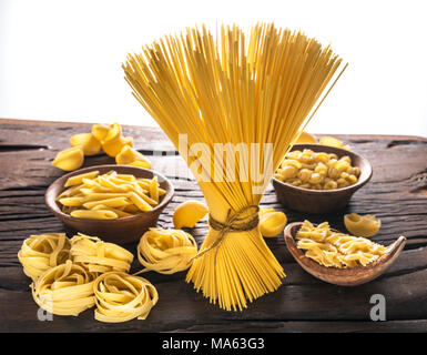 Different pasta types on wooden table. White background. Stock Photo