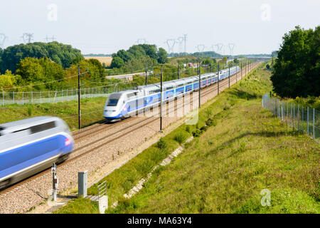 Two high-speed TGV Duplex trains in Atlantic livery from french company SNCF passing each other on the South-East TGV line in the countryside. Stock Photo