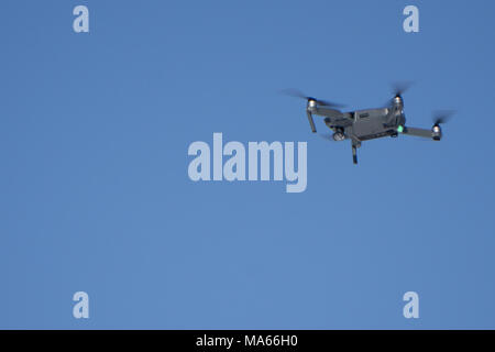 Drone Quadcopter with camera flying on a clear sky background Stock Photo