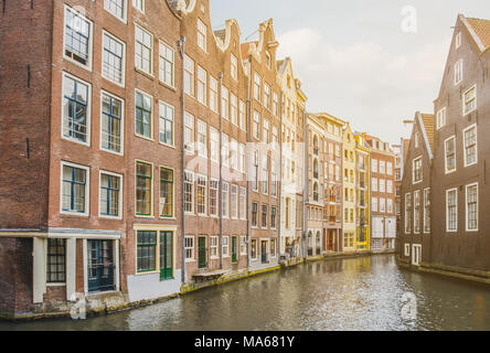 Traditional old building facade in Amsterdam along the canal coast , city center Stock Photo