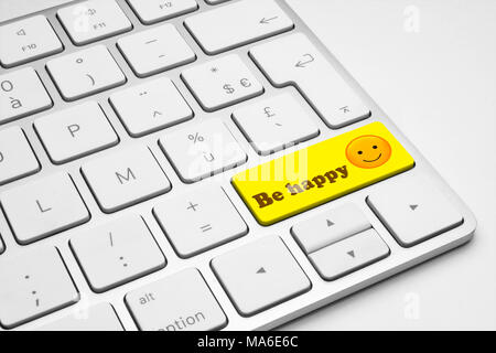 Be happy yellow push button on a white isolated keyboard - internet, web, social media and business illustrative concept. Stock Photo
