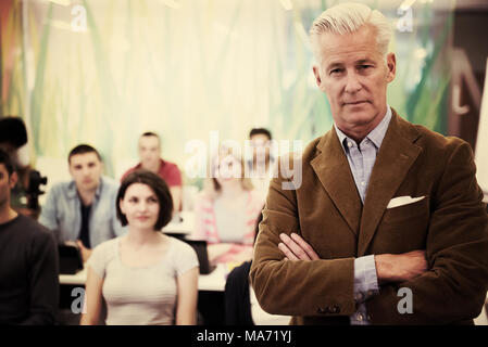 portrait of confident teacher,  students group in background Stock Photo