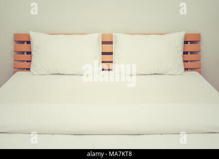 white blankets and pillows on the wood bed in bedroom Stock Photo