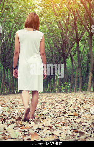 Sad woman walking alone in the forest feeling sad and lonely Stock Photo
