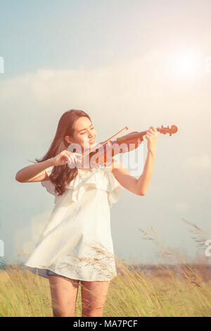 Beautiful women enjoy playing violin Stock Photo - Alamy