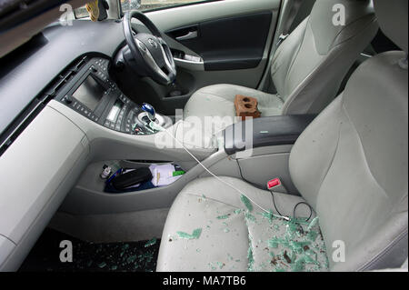 A car recently broken into with offending brick visible on driver seat - parked on a London street Stock Photo