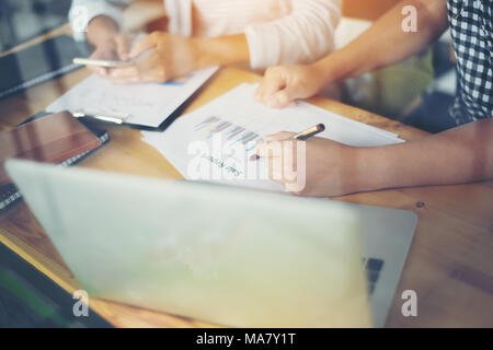 Business team meeting analysis financial chart together at cafe.with reflection from windows Stock Photo