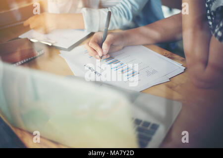 Business team meeting analysis financial chart together at cafe.with reflection from windows Stock Photo