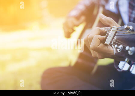 Hipster handsome young man practicing in playing guitar,freedom life,happy time. Stock Photo