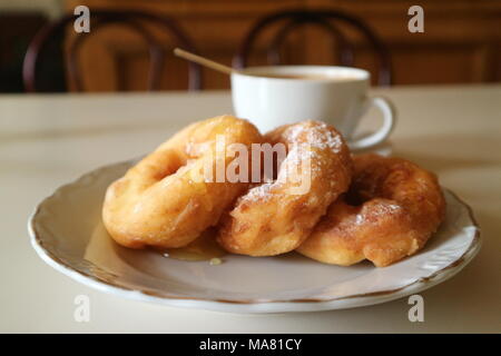 fried donuts with honey and coffee on the table Stock Photo