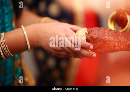 groom puts bangle in bride hand at bangle ceremony Stock Photo - Alamy