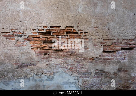 Cracked and decayed brick stucco wall texture background weathered long time ago. Stock Photo