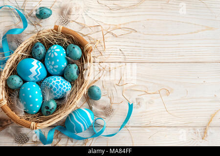 Easter background with Easter eggs and spring flowers. Top view with copy space. Stock Photo