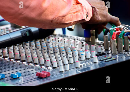 Sound engineer adjusting audio mixing console Stock Photo