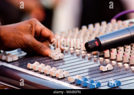 Sound engineer adjusting audio mixing console Stock Photo
